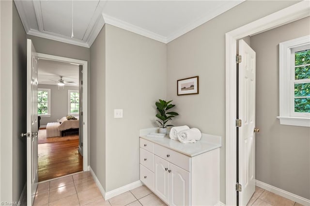 corridor featuring crown molding, plenty of natural light, and light tile patterned floors