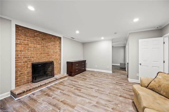 unfurnished living room with ornamental molding, a brick fireplace, and light wood-type flooring