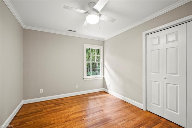 unfurnished bedroom featuring ornamental molding, a closet, ceiling fan, and light hardwood / wood-style flooring