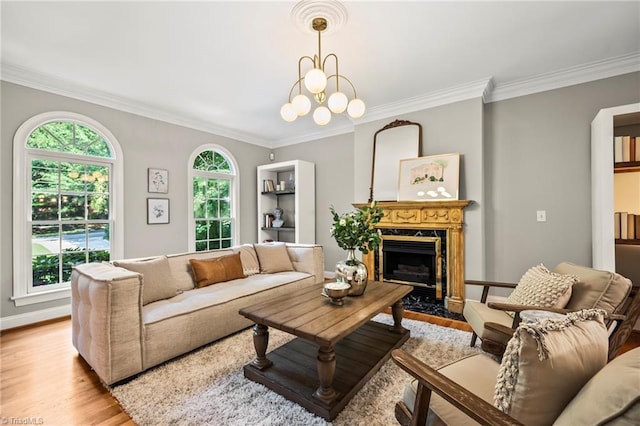 living room with ornamental molding, plenty of natural light, a fireplace, and light hardwood / wood-style floors