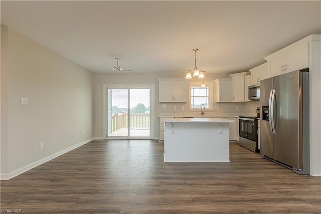 2075 Old Wesley Chapel Rd, Linwood, NC 27299 - kitchen with stainless steel appliances, light countertops, a kitchen island, white cabinets, and baseboards
