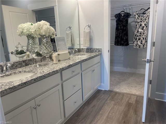 213 Cason Dr, Gibsonville, NC 27249 - full bathroom with double vanity, a spacious closet, and wood finished floors