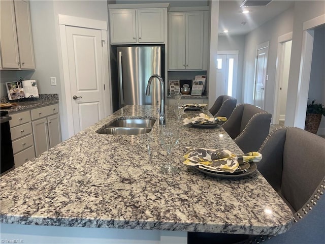 213 Cason Dr, Gibsonville, NC 27249 - kitchen with freestanding refrigerator, a sink, a spacious island, light stone counters, and a kitchen breakfast bar