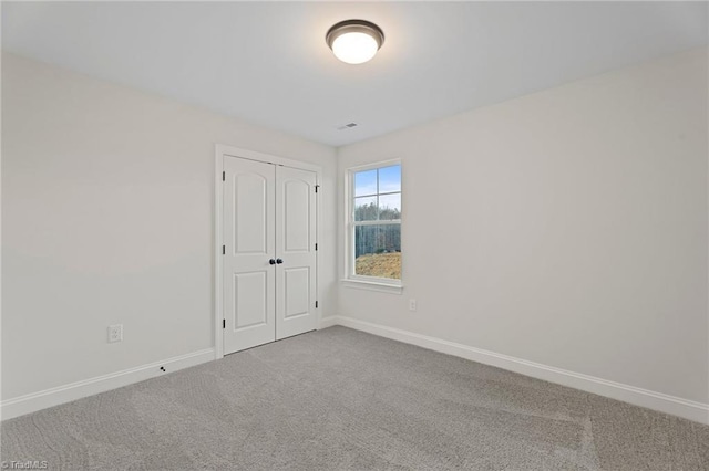 carpeted empty room featuring baseboards