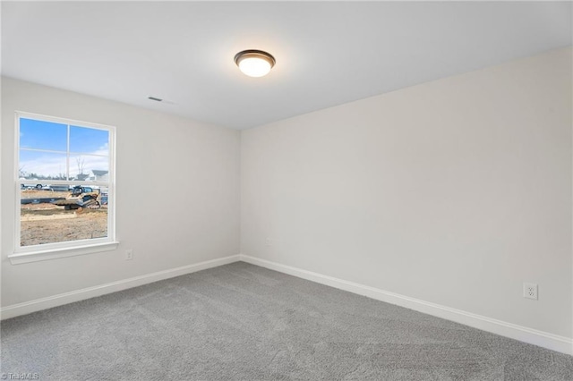 carpeted spare room featuring baseboards