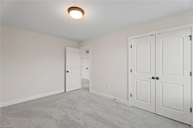 unfurnished bedroom with carpet, baseboards, and a closet