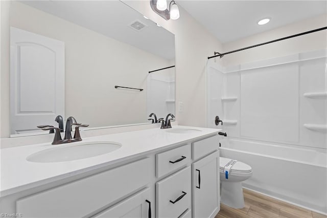 bathroom featuring visible vents, wood finished floors, a sink, and toilet