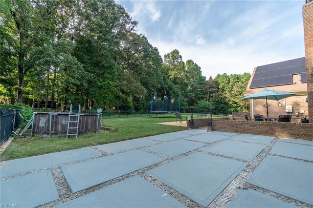4905 Deer Pointe Ct, Greensboro, NC 27406 - view of patio / terrace with a trampoline, an outdoor pool, and fence