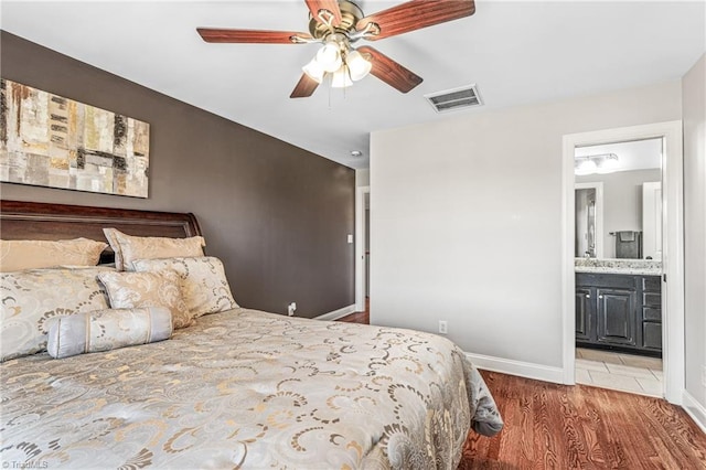 bedroom featuring hardwood / wood-style floors, connected bathroom, and ceiling fan