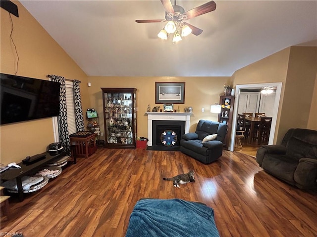 living room featuring ceiling fan, hardwood / wood-style floors, and vaulted ceiling