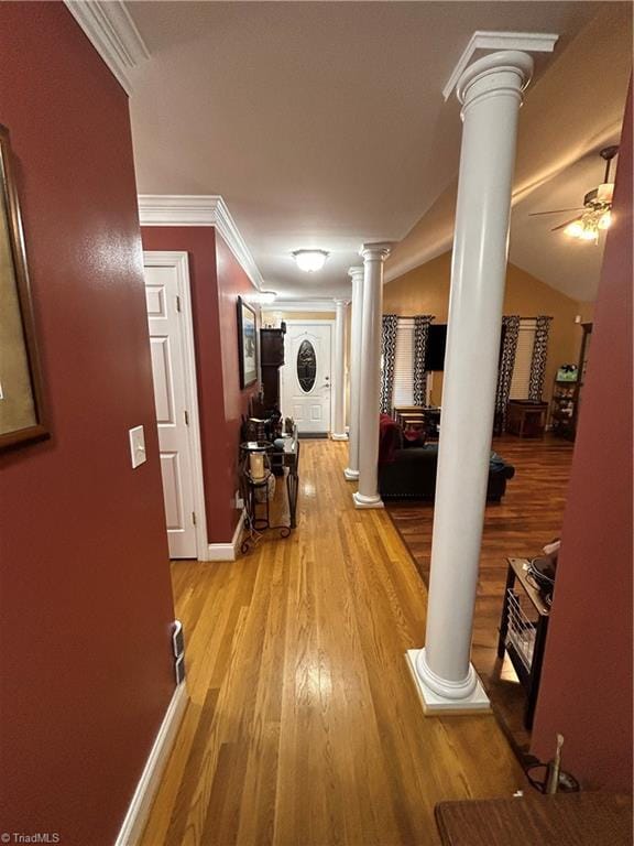 hall with vaulted ceiling, decorative columns, light hardwood / wood-style flooring, and crown molding