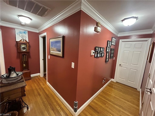 hallway with hardwood / wood-style floors and crown molding