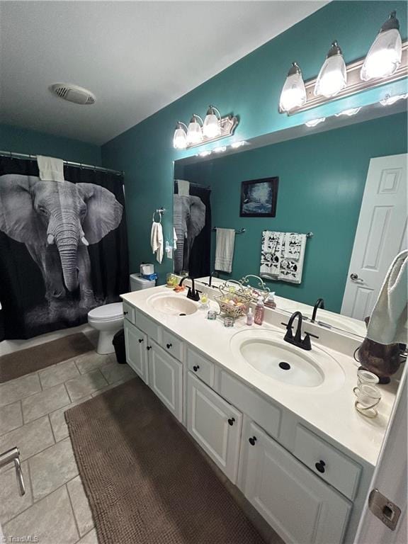 bathroom with tile patterned flooring, vanity, and toilet