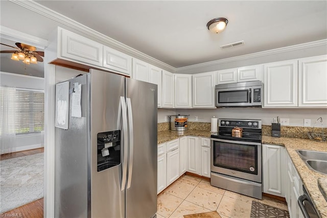 kitchen featuring white cabinets, light stone counters, crown molding, and appliances with stainless steel finishes