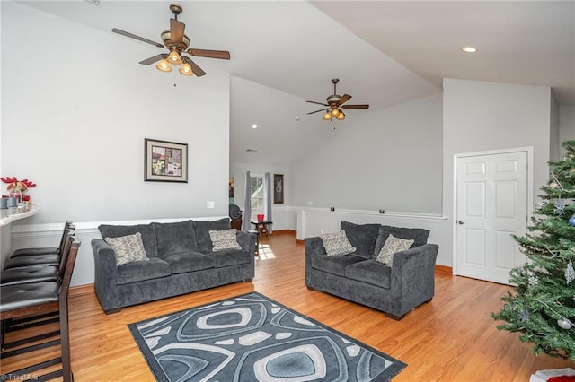 living room with ceiling fan, wood-type flooring, and vaulted ceiling