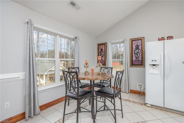 tiled dining area with lofted ceiling