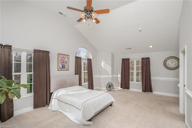 carpeted bedroom with multiple windows, ceiling fan, and high vaulted ceiling