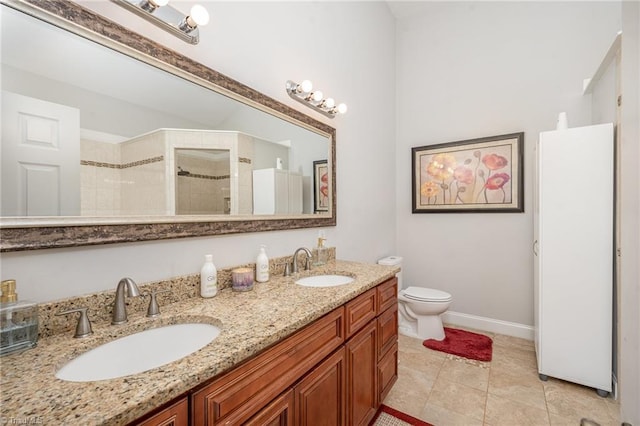 bathroom featuring toilet, a tile shower, vanity, and tile patterned floors