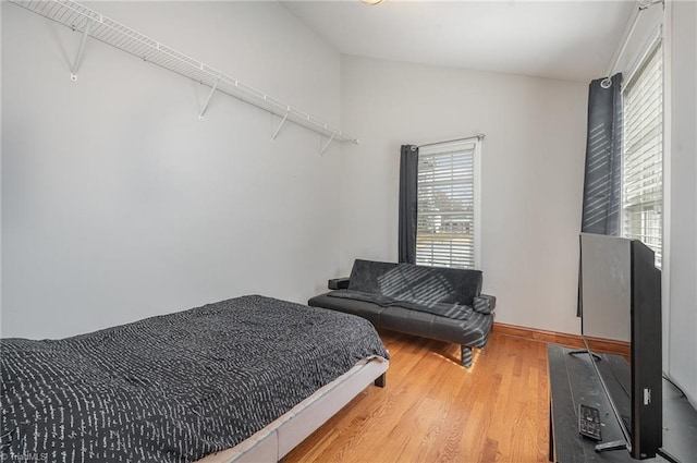 bedroom featuring hardwood / wood-style flooring and lofted ceiling