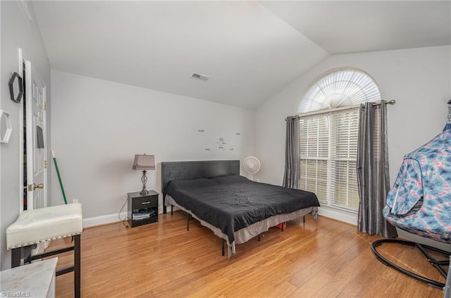 bedroom with lofted ceiling and light wood-type flooring