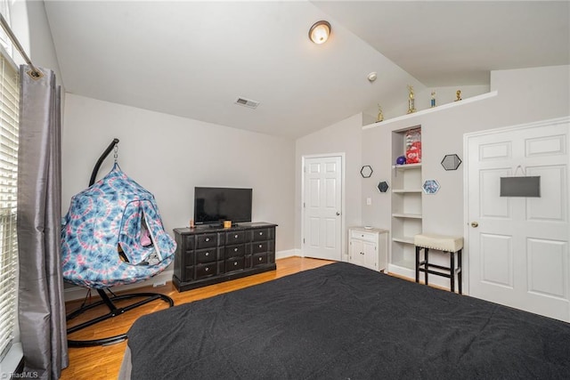 bedroom featuring hardwood / wood-style floors and lofted ceiling