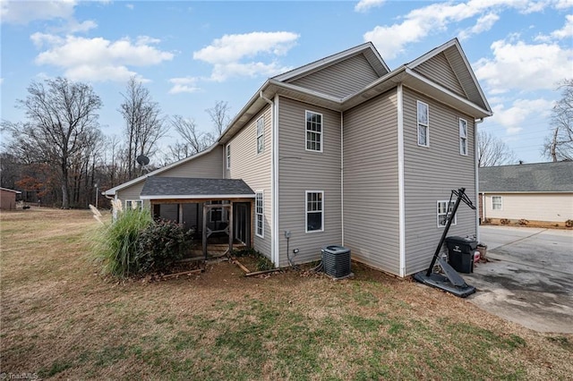 rear view of house with a lawn and cooling unit