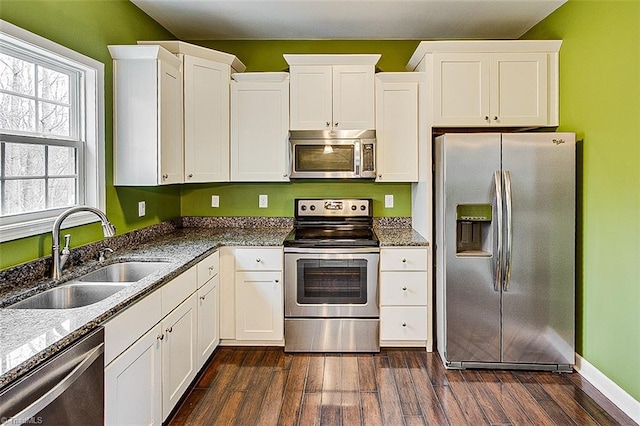 kitchen featuring appliances with stainless steel finishes, white cabinetry, and a sink