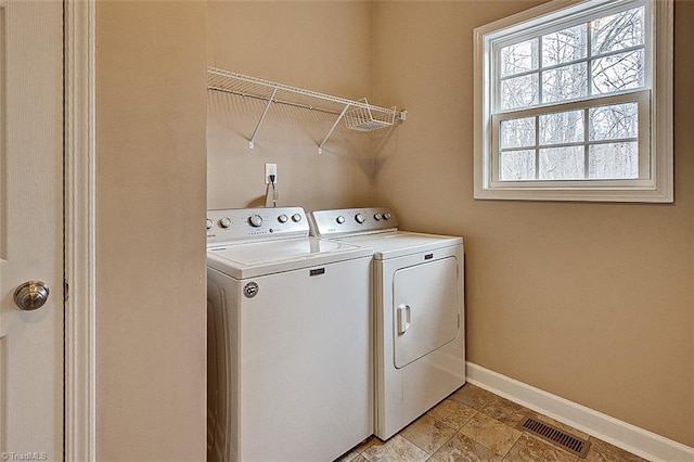 laundry area featuring laundry area, baseboards, visible vents, and separate washer and dryer