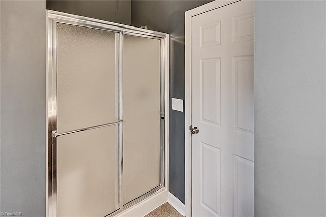 full bathroom featuring baseboards and a stall shower