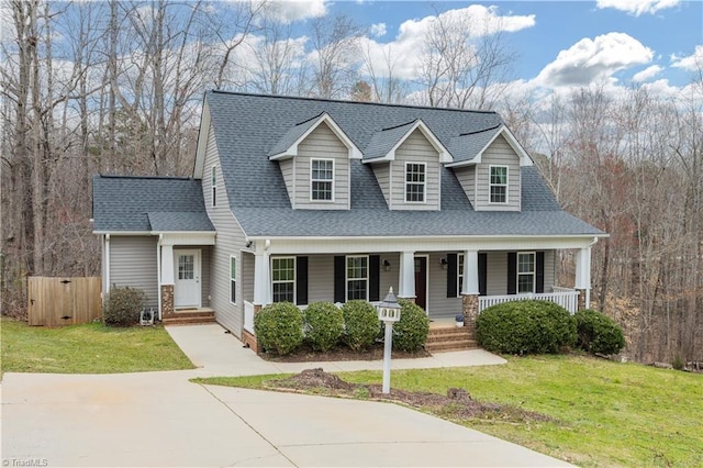 view of front facade with covered porch, a front yard, and a shingled roof