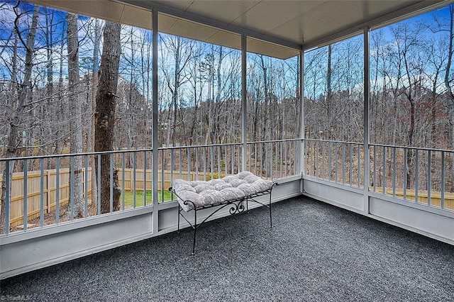 unfurnished sunroom featuring a forest view