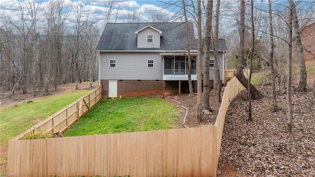 view of front of property with crawl space, a fenced backyard, a front lawn, and a sunroom