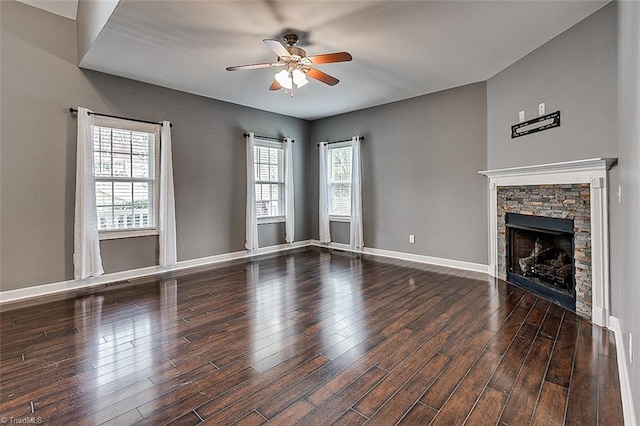 unfurnished living room with ceiling fan, baseboards, wood finished floors, and a fireplace