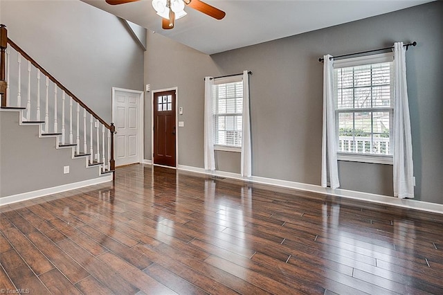 entrance foyer with lofted ceiling, a ceiling fan, wood finished floors, stairway, and baseboards