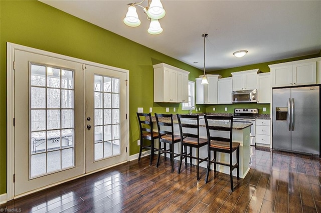 kitchen featuring dark countertops, french doors, white cabinets, stainless steel appliances, and dark wood-style flooring