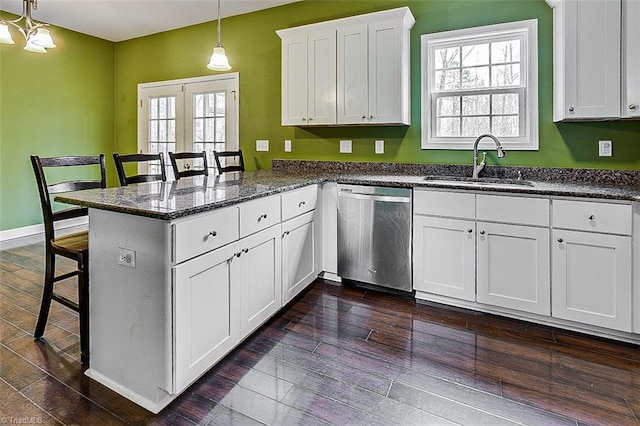 kitchen with dark wood-type flooring, a sink, a peninsula, white cabinets, and dishwasher