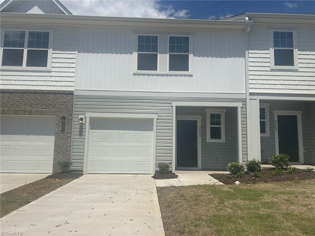 townhome / multi-family property featuring concrete driveway and an attached garage