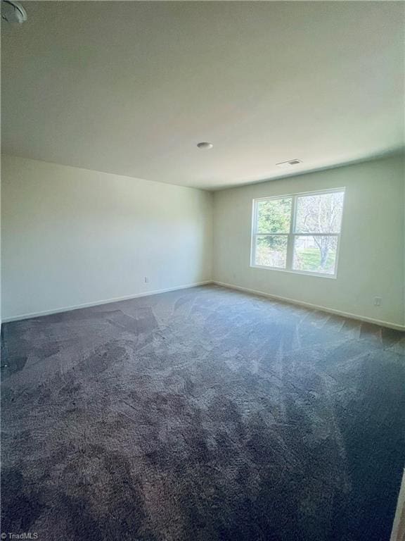 unfurnished room with carpet and baseboards