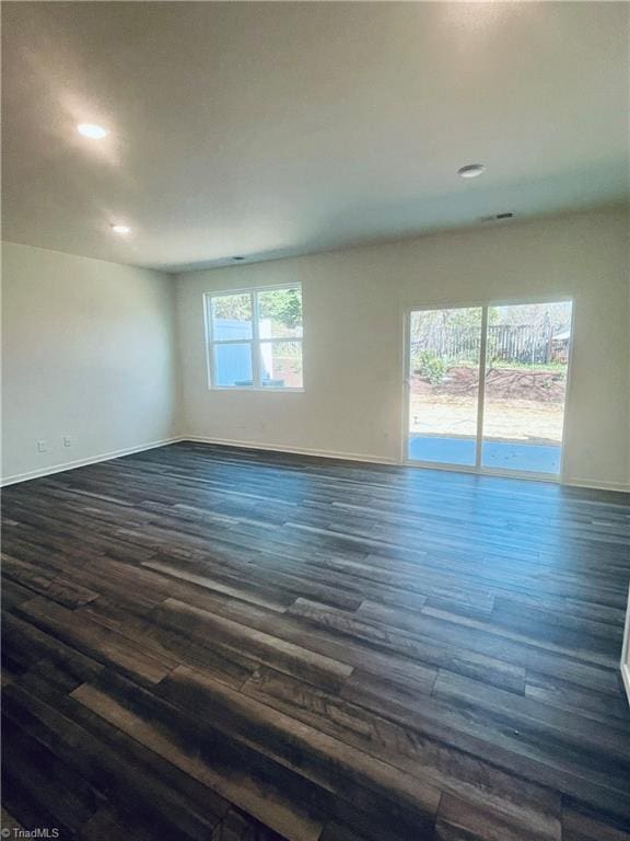 unfurnished room featuring dark wood-type flooring, baseboards, and recessed lighting