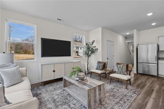 living area with visible vents, wood finished floors, baseboards, and recessed lighting