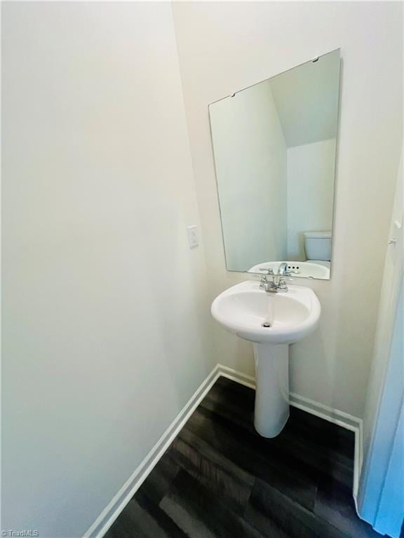 bathroom with wood finished floors and baseboards