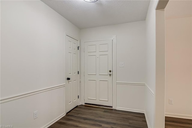 4814 Tower Rd, Greensboro, NC 27410 - doorway with dark wood-style floors, a textured ceiling, and baseboards
