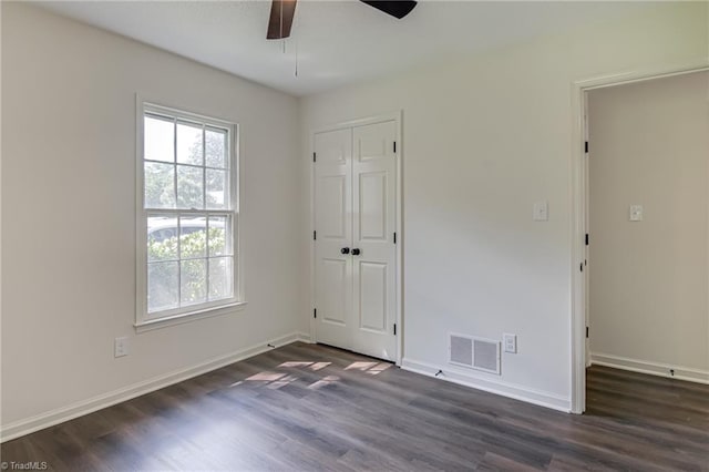 4814 Tower Rd, Greensboro, NC 27410 - unfurnished bedroom with dark wood-style flooring, baseboards, a closet, and a ceiling fan