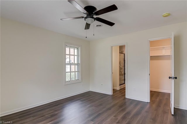 4814 Tower Rd, Greensboro, NC 27410 - unfurnished bedroom featuring a spacious closet, dark wood finished floors, baseboards, and a closet