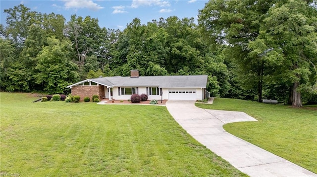 657 Spring St, Walnut Cove, NC 27052 - view of front of home with concrete driveway, an attached garage, a front yard, and a chimney