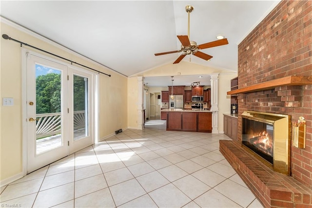 657 Spring St, Walnut Cove, NC 27052 - unfurnished living room featuring vaulted ceiling, light tile patterned floors, ceiling fan, a fireplace, and decorative columns