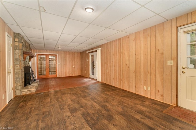 657 Spring St, Walnut Cove, NC 27052 - unfurnished living room featuring wooden walls, a paneled ceiling, wood finished floors, and a wood stove