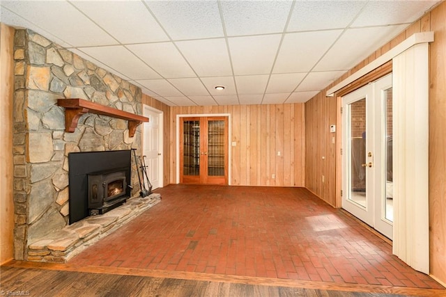 657 Spring St, Walnut Cove, NC 27052 - unfurnished living room with french doors, a drop ceiling, brick flooring, and wood walls