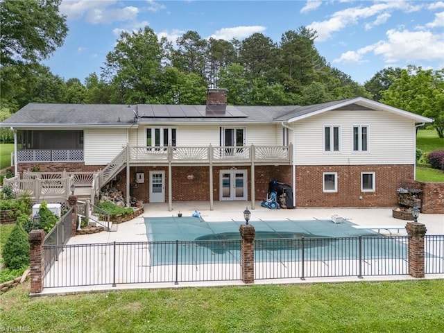 657 Spring St, Walnut Cove, NC 27052 - rear view of property featuring french doors, solar panels, a covered pool, and brick siding