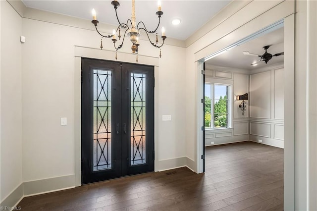 entryway featuring ceiling fan with notable chandelier, dark wood-type flooring, and french doors